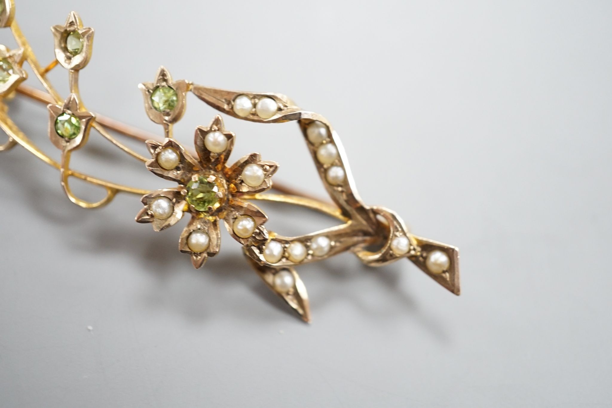 An Edwardian yellow metal, seed pearl and garnet set spray brooch, 55mm, gross weight 4.8 grams.